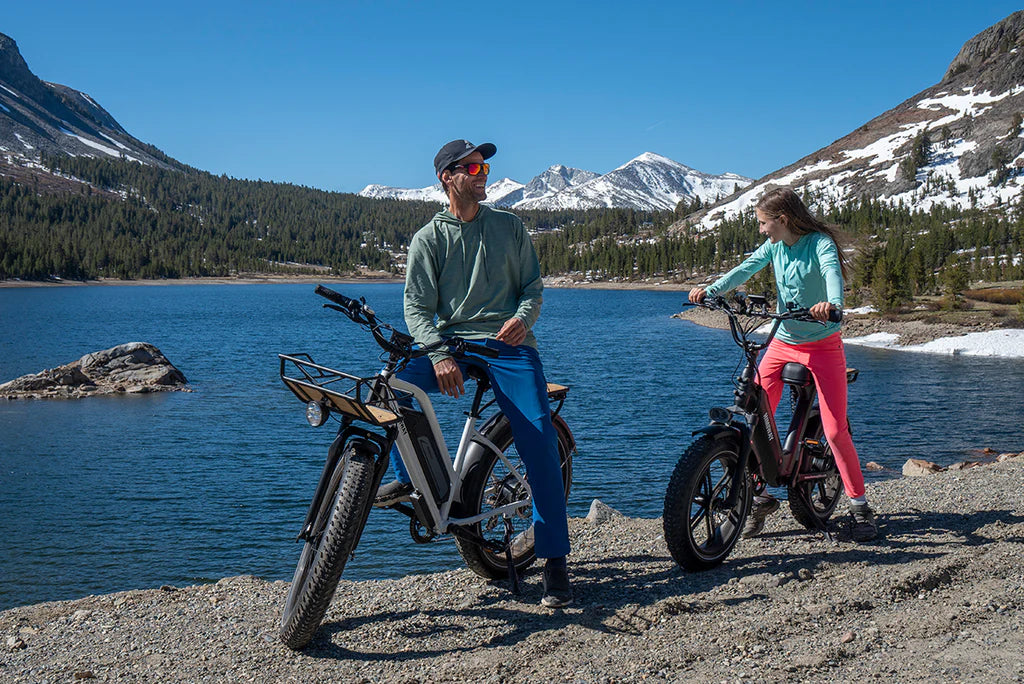 Mann und Frau mit E-bike und E-Fatbike an einem See in den Bergen